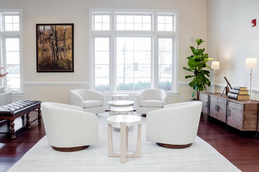 a living room with white furniture and a large window at Broadlands Apartments in Ashburn, Virginia